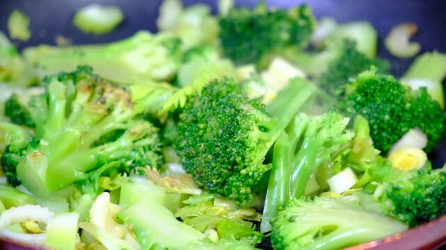 Stewing vegetables, broccoli, celery on cast iron, steaming, cooking process, healthy meal