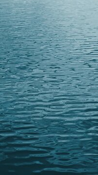 Blue water ripples in a vertical slow-motion video.
A close-up shows a real blue water surface with gentle overlapping waves.