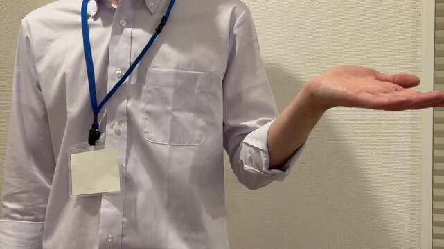 片手を出して案内するビジネスマン
