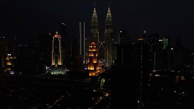 KL city skyline with illuminated Twin Towers at night. Great aerial view drone