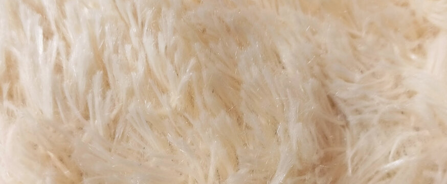 Beige knitted-fur fabric background. For wallpapers, dolls, and presentations.