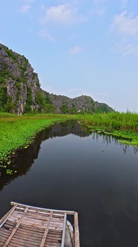 Traditional Vietnamese Bamboo Boat Gliding Across Van Long Wetland, Ninh Binh, Vietnam