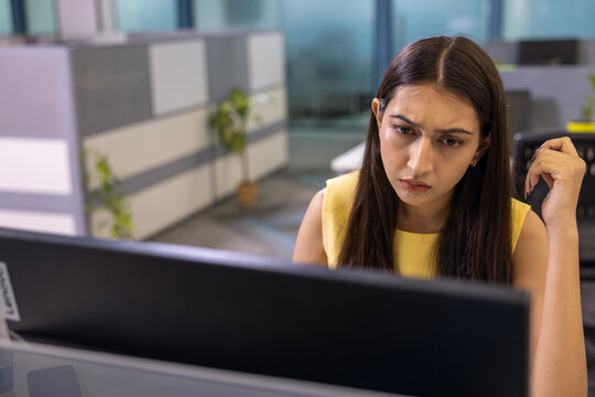 Sad and worried woman office employee responsible manager spending time at office desk.
She unable to find correct decision answer with difficult hard problem while look at the laptop