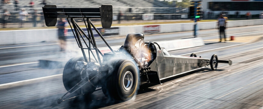 A high-speed drag racing scene featuring a powerful dragster accelerating down the track, emitting smoke and showcasing its impressive design and performance.