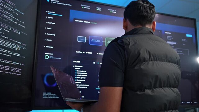 Dedicated software developer reviewing complex code on an expansive monitor in a contemporary tech workspace