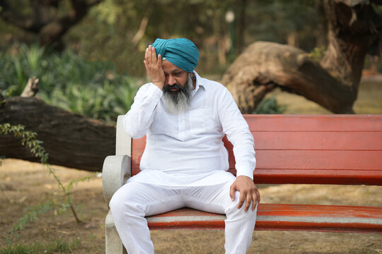 Unhappy Senior sikh man Portraits. Weeping senior aged man in park. One side painful eye
