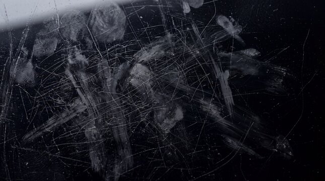 Fingerprints and Scratches on Dark Glass Screen Surface