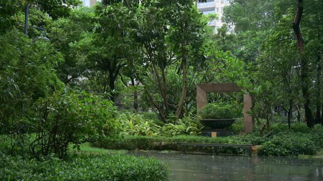 Heavy rain pouring over lush residential community garden with wet pavement video with sound