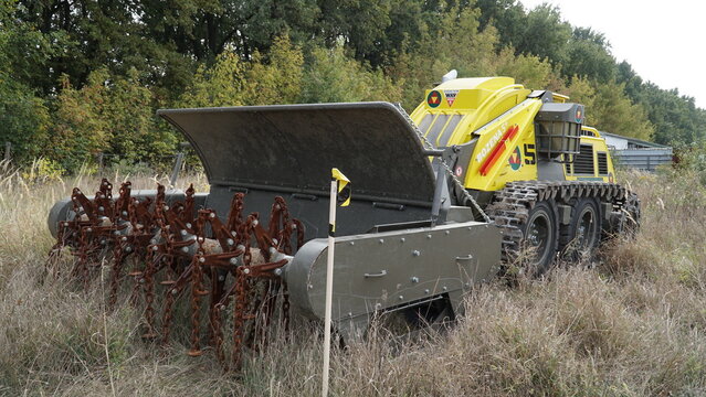 KYIV, UKRAINE - OCTOBER 2, 2024: A Bozena 5+ remote-controlled demining system parked in a field. Unmanned robotic vehicle for humanitarian landmine clearance featuring Ukrainian text.
