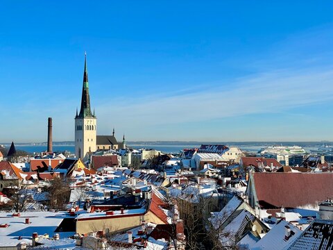 St Olafs Church spire and red roofs in Tallinn Old Town with clear blue sky, Estonia