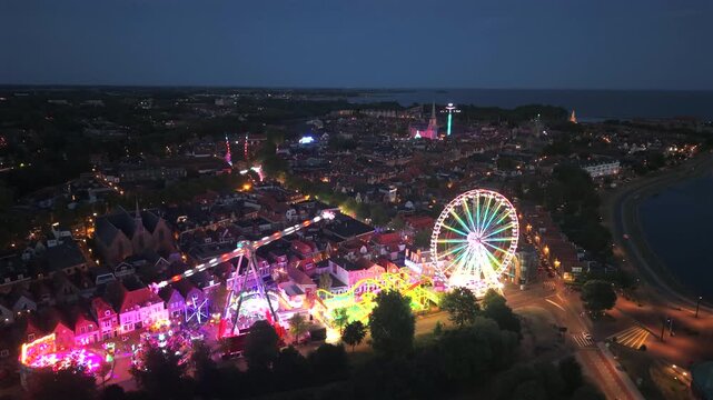 Illuminated Hoorn fair and ferris wheel at blue hour