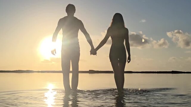 casal romantico andando juntos no p&ocirc;r do sol 
