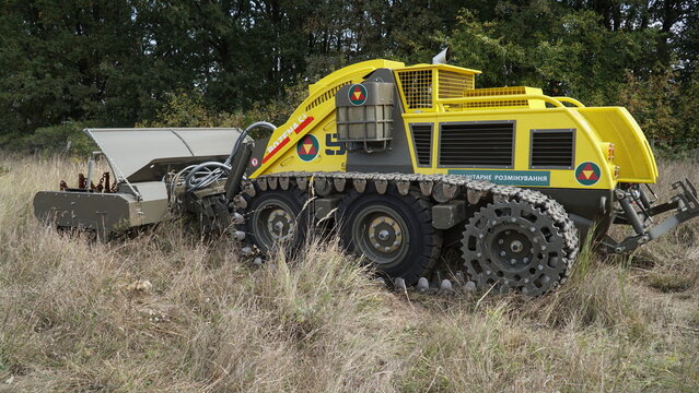 KYIV, UKRAINE - OCTOBER 2, 2024: A Bozena 5+ remote-controlled demining system parked in a field. Unmanned robotic vehicle for humanitarian landmine clearance featuring Ukrainian text.