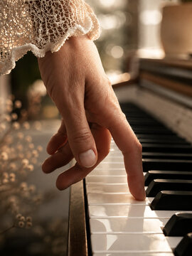 playing the piano Close Up of Hand Playing Piano Keys in Warm Golden Light