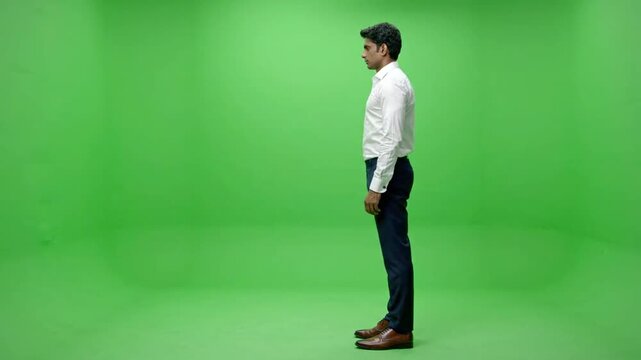 Side profile of man standing in green screen studio