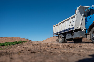 Dump truck driving on a dirt road at a construction site © MatiasLeonel