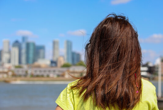 Rear view of young woman looking at Canary Wharf skyline in London