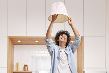 Obraz premium Young man changing a light bulb