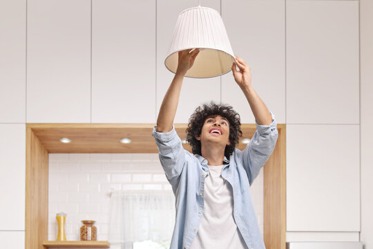 Young man changing a light bulb