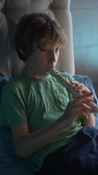 A little boy learns to play the flute at home, practicing with focus and enthusiasm in a cozy, warm setting. A charming scene of early musical exploration, creativity, and childhood growth.