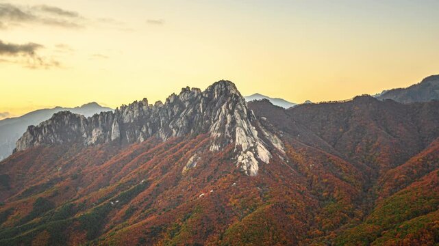 A 4K time-lapse video (zoom in) reveals the morning scenery of autumn foliage and uniquely shaped rock formations at Sinseondae Cliff, including Ulsanbawi Rock, on Mount Seorak in South Korea.