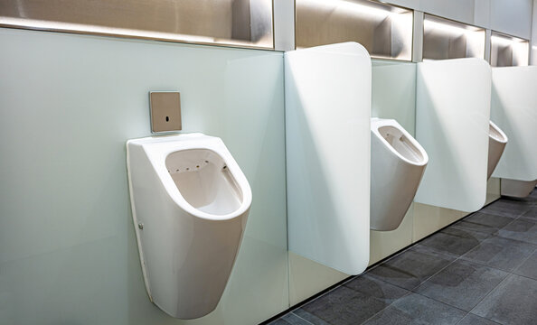 Sensor-operated urinals with privacy walls in a public toilet