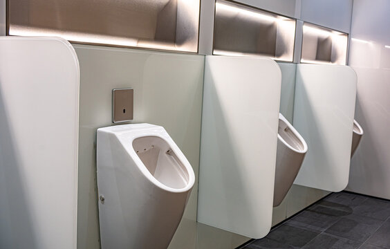 Sensor-operated urinals with privacy walls in a public toilet