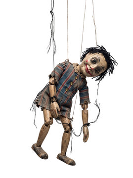 Old creepy wooden marionette puppet with broken strings hanging isolated on transparent background.