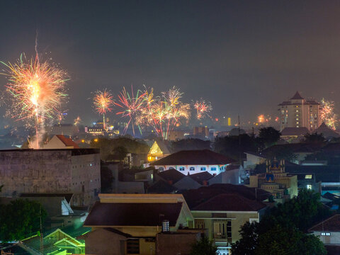 Colorful fireworks exploding in the night sky over a city residential area during New Year celebration or festival