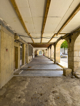 Covered stone arcade walkway of the bastide village with rows of arches, Gers, Monfort, France
