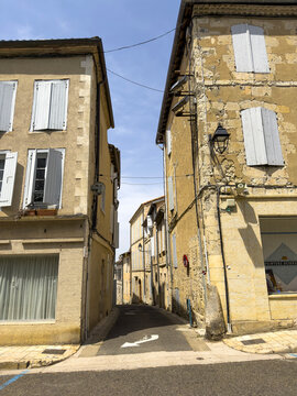 Narrow alley between traditional stone houses with shuttered windows, Gers, Lectoure, France