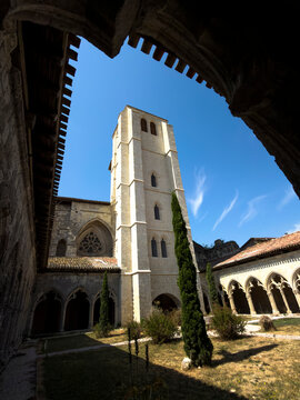 Bell tower and rose window of the collegiate church viewed through the cloister arcade, Gers, La Romieu, France