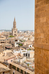 Fototapeta premium Panorama of the rooftops of Palma, Mallorca, Spain, seen from a corner of the Catedral de Mallorca, with the tower of Església de Santa Eulàlia in the distance.
