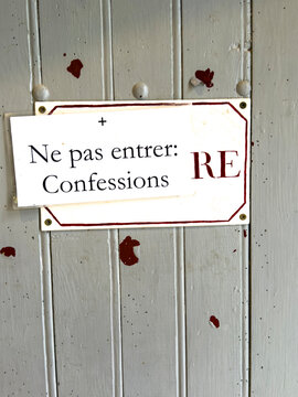 Weathered confessional door with a 'Ne pas entrer' sign at Saint Mary abbey, Gers, Boulor, France