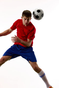 Close action view of teenager footballer tracking ball in flight. Concept of reaction speed, visual focus, ball awareness and match decision making.