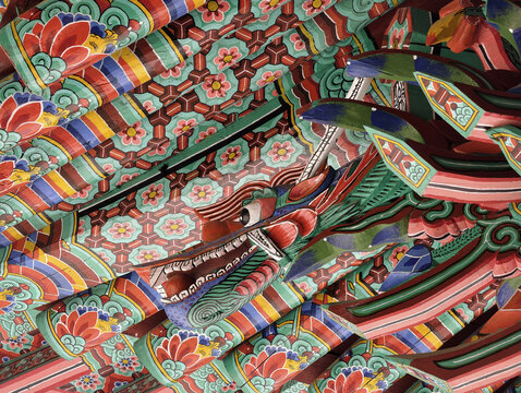 Close-up of traditional multicolored Dancheong painting on wooden roof brackets of a Korean temple
