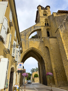 Gothic bell tower archway spanning a cobbled street in the old town, Gers, Mirande, France
