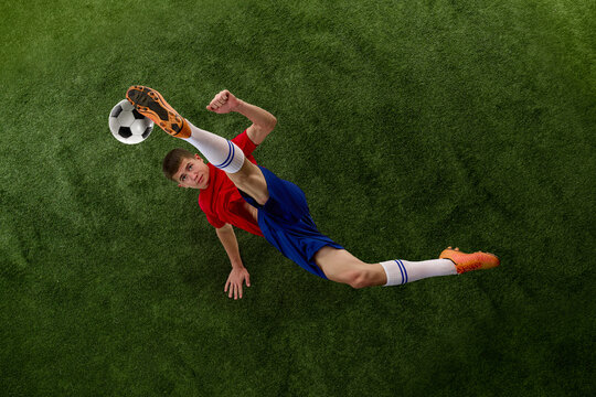 Top view of bicycle kick above textured football pitch. Concept of tactical sports design, acrobatic action, field geometry and editorial football layouts.