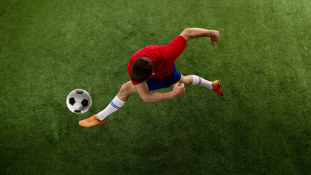 Aerial perspective of teen soccer player cutting past ball. Concept of evasive movement, agility drills, tactical change and attacking creativity.