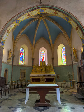 Painted ribbed vault apse with a gilded altarpiece and stained glass windows in the Church of Saint James the Greater, Gers, Tilliac, France