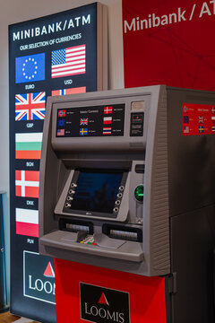 August 15, 2026, Stavanger, Norway - Loomis Minibank/ATM machine displaying available currencies and country flags at Stavanger Airport