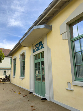 Angled view of the Foyer Familial building facade with green doors and windows, Gers, Tilliac, France