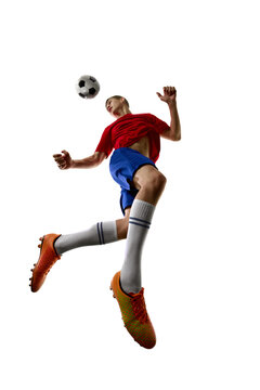 Low angle jump with football passing above athlete head. Concept of aerial play, heading preparation, athletic elevation and competitive timing.