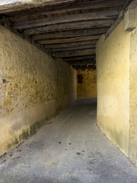 Covered stone passageway running between old village houses, Gers, Montesquiou, France