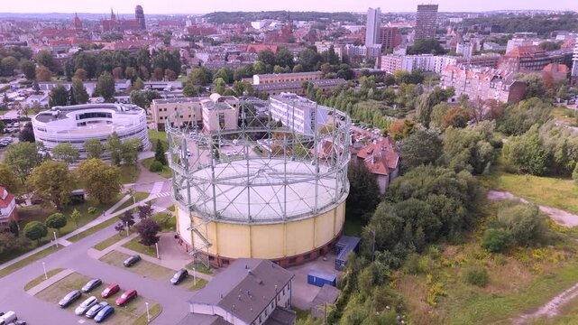 High-Angle Aerial View of an Industrial Gas Holder and Cityscape for Energy Infrastructure and Urban Planning