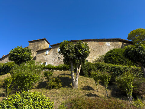 Stone village houses on a hillside surrounded by trees, Gers, Montesquiou, France