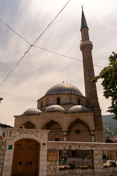 Sarajevo, Bosnia and Herzegovina - 16 June 2025: View of the historic Gazi Husrev-beg Mosque with its stone dome and minaret under a cloudy sky.