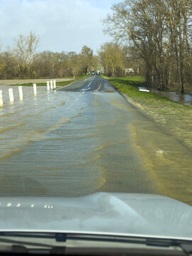 Flooded country road viewed through a car windshield, Gers, Ilse Jourdain, France
