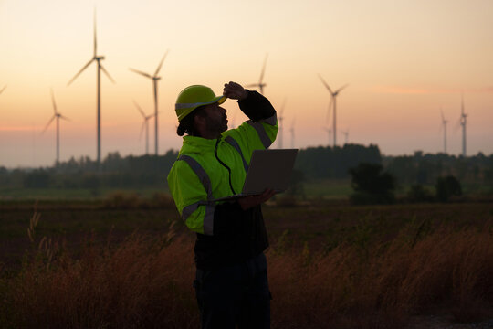 Engineer technician working at wind turbine power plant in the early morning Renewable energy solutions for climate change, clean energy