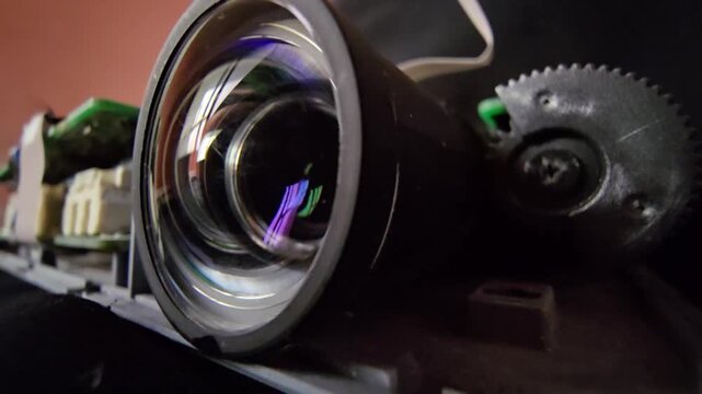 Close up shot of an exposed optical lens system featuring precise focus gears, circuit board components, and anti-reflective lens coating. Ideal for engineering and futuristic tech concepts.